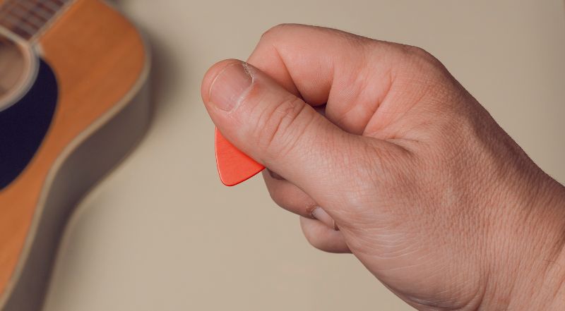 how to hold a guitar pick